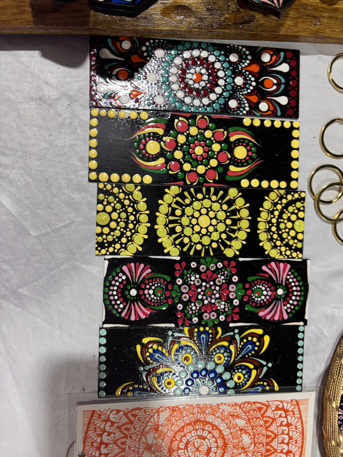 Detailed dot-painted artwork and decorated notebooks on the exhibition table