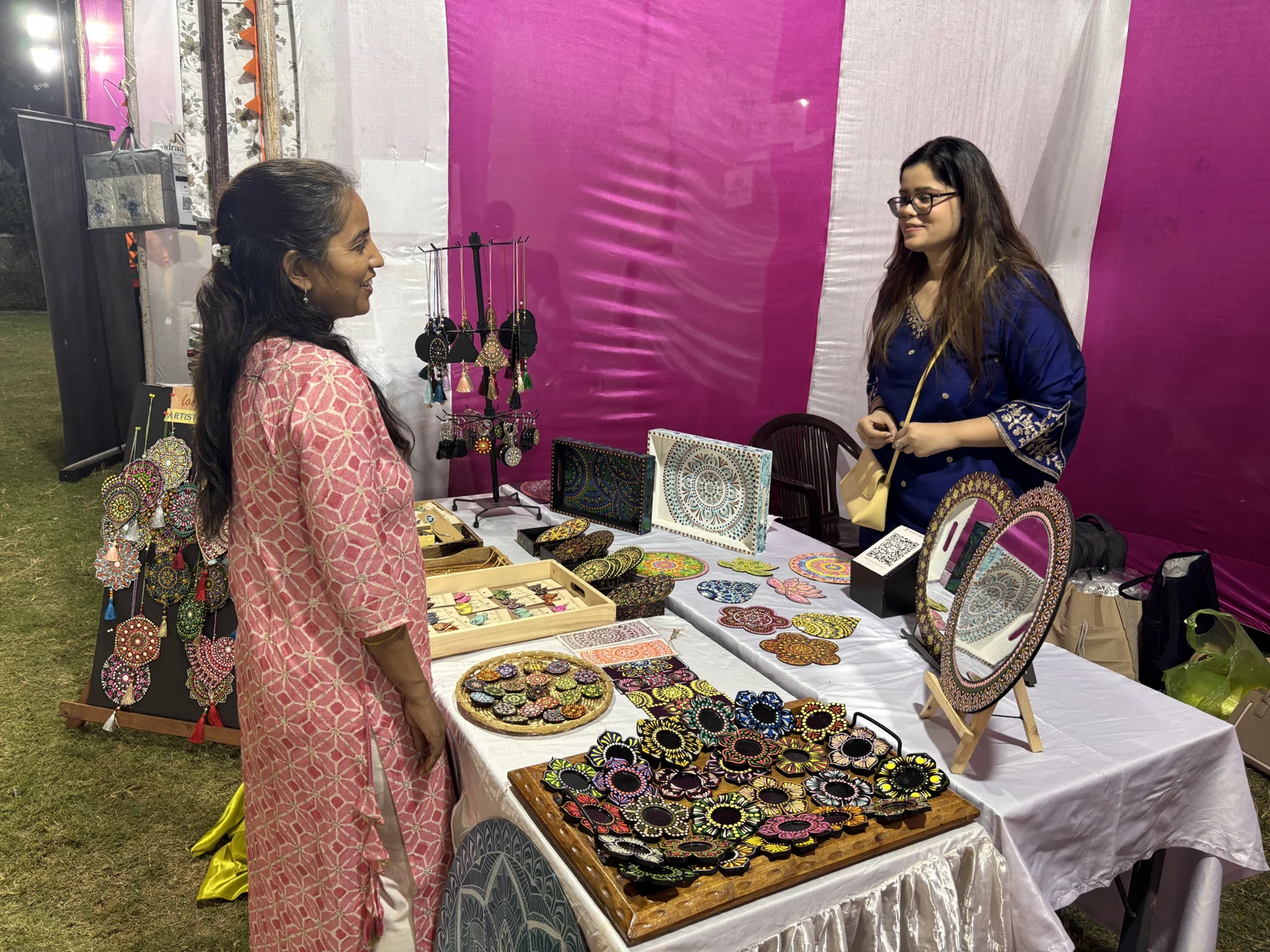 Nehal talking with a visitor across the exhibition table