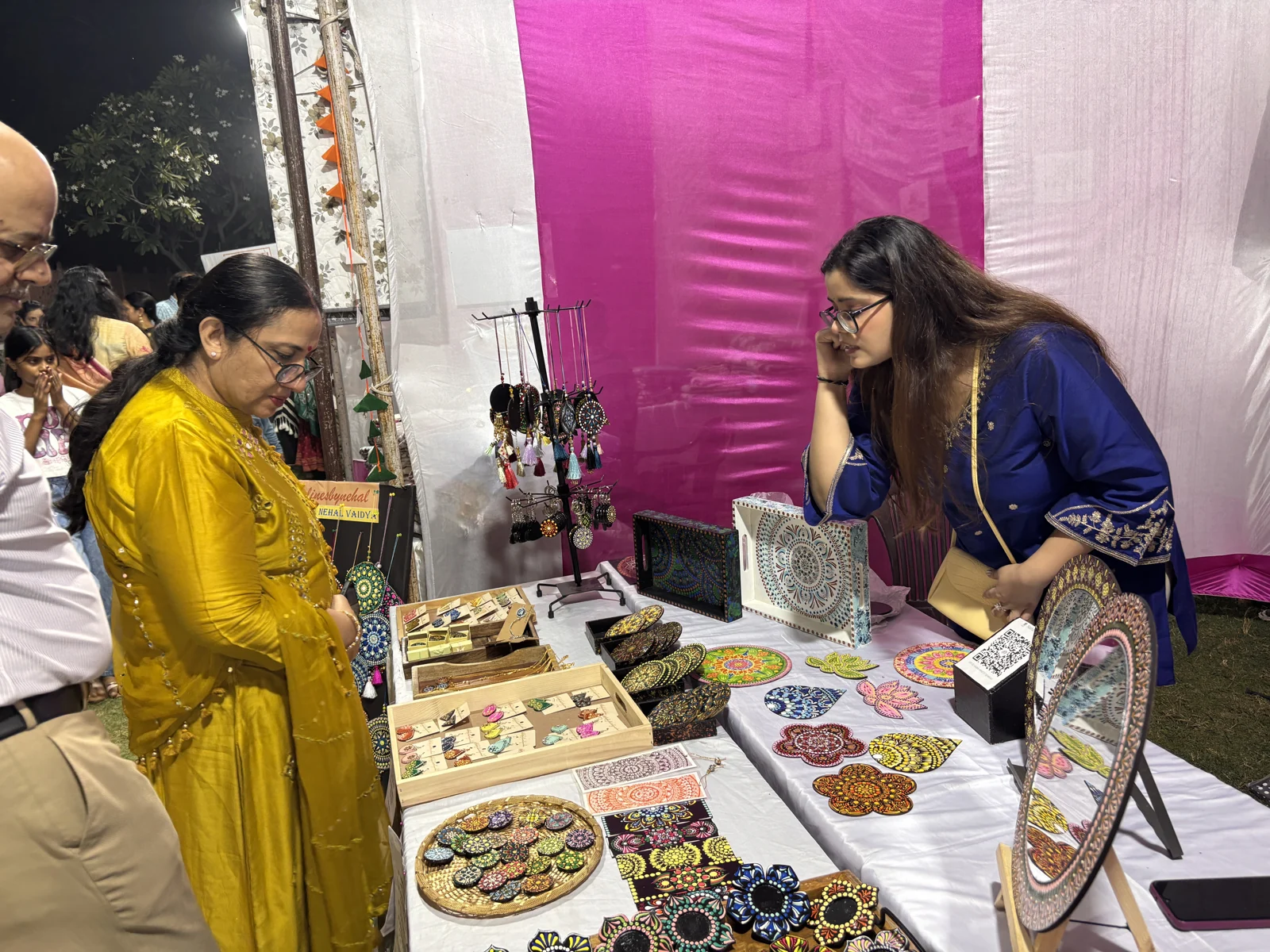 Nehal showing handmade pieces to visitors at the exhibition stall