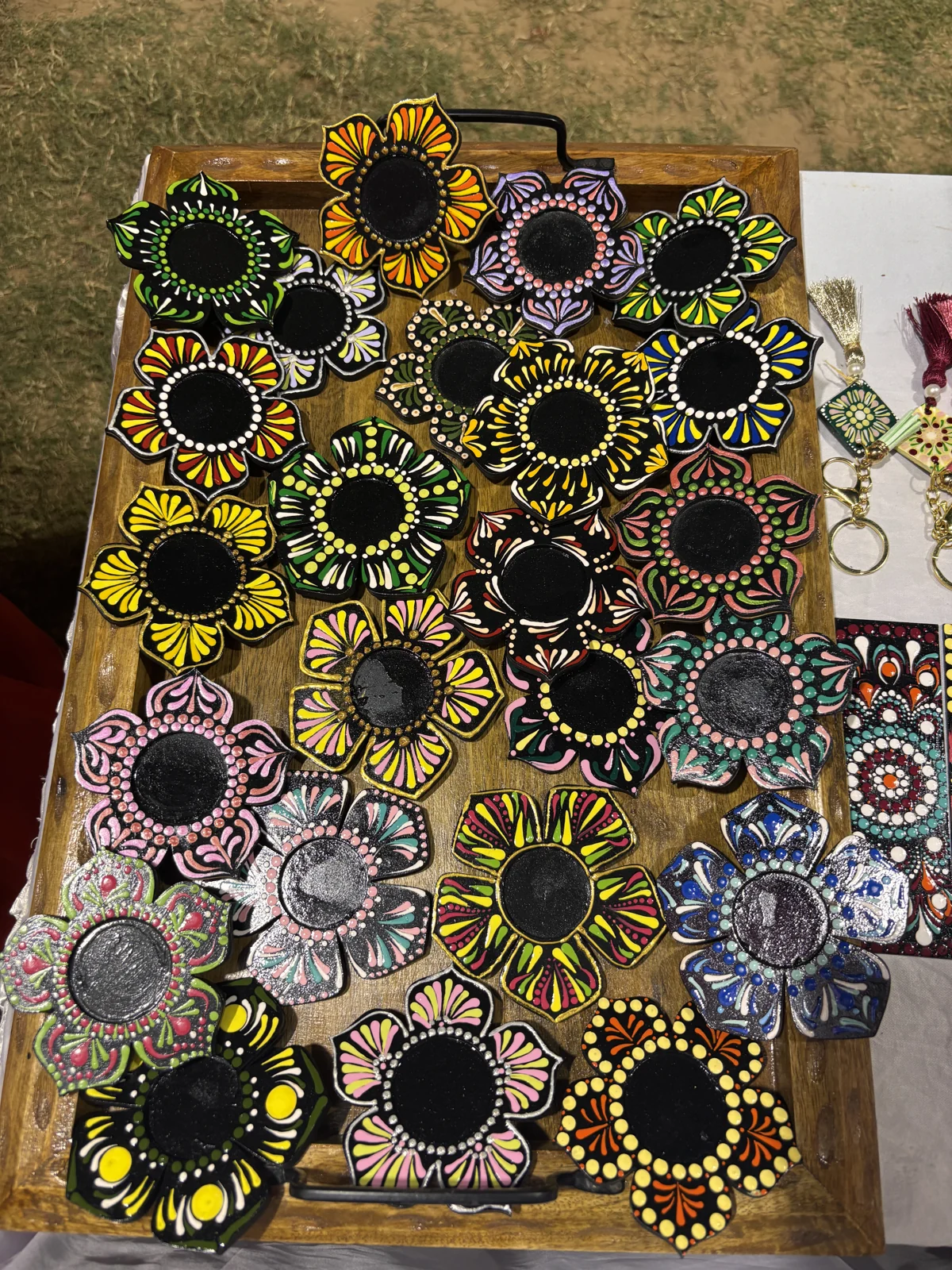 Small mirrors with colourful hand-painted mandala borders arranged on a wooden tray